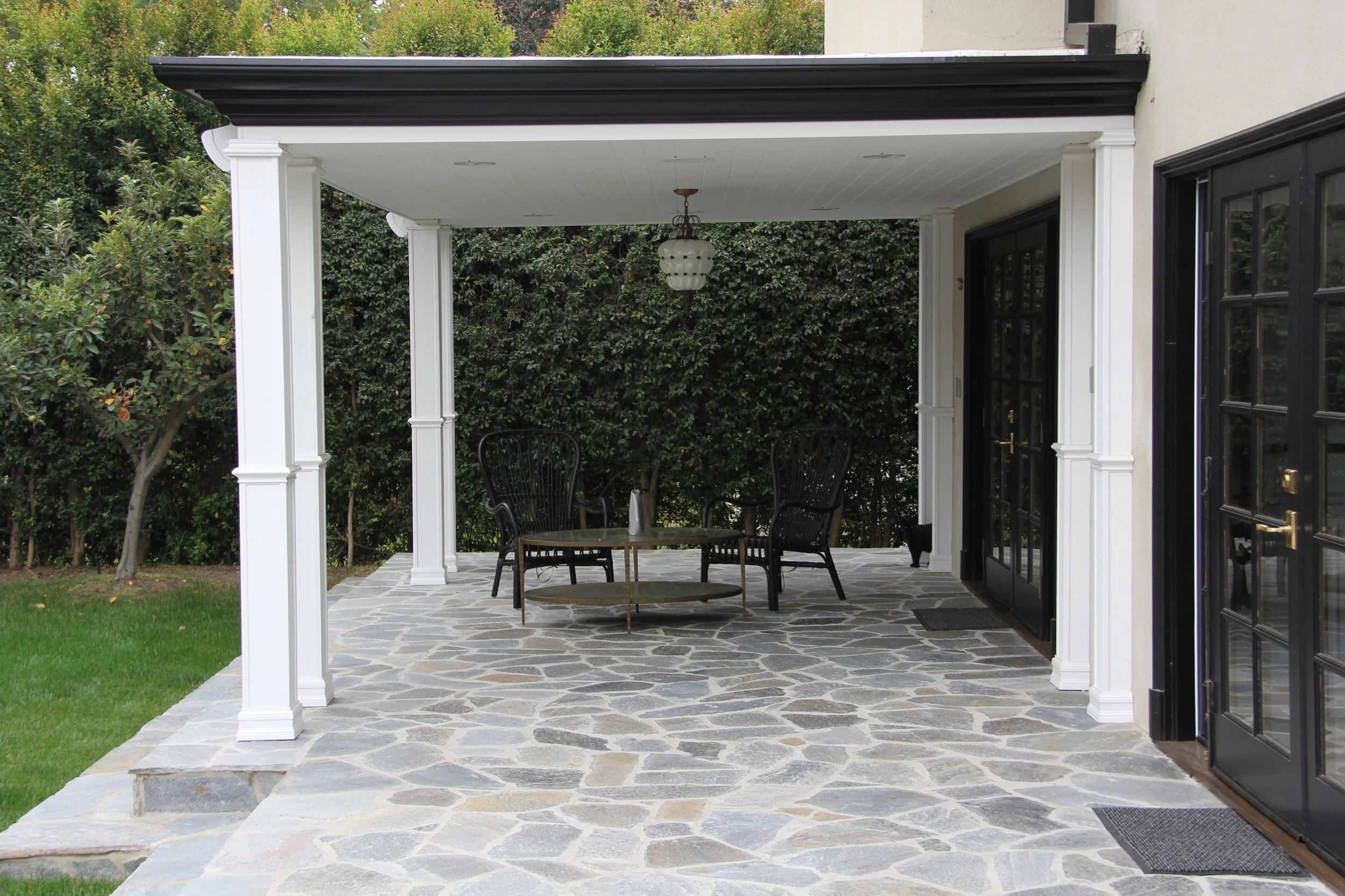 Covered outdoor patio with stone flooring in a Hancock Park Los Angeles home