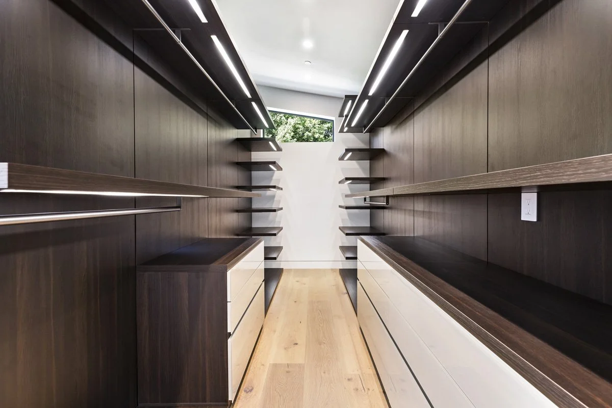 Beverly Hills custom walk-in closet with dark wood cabinetry, open shelving, and integrated lighting