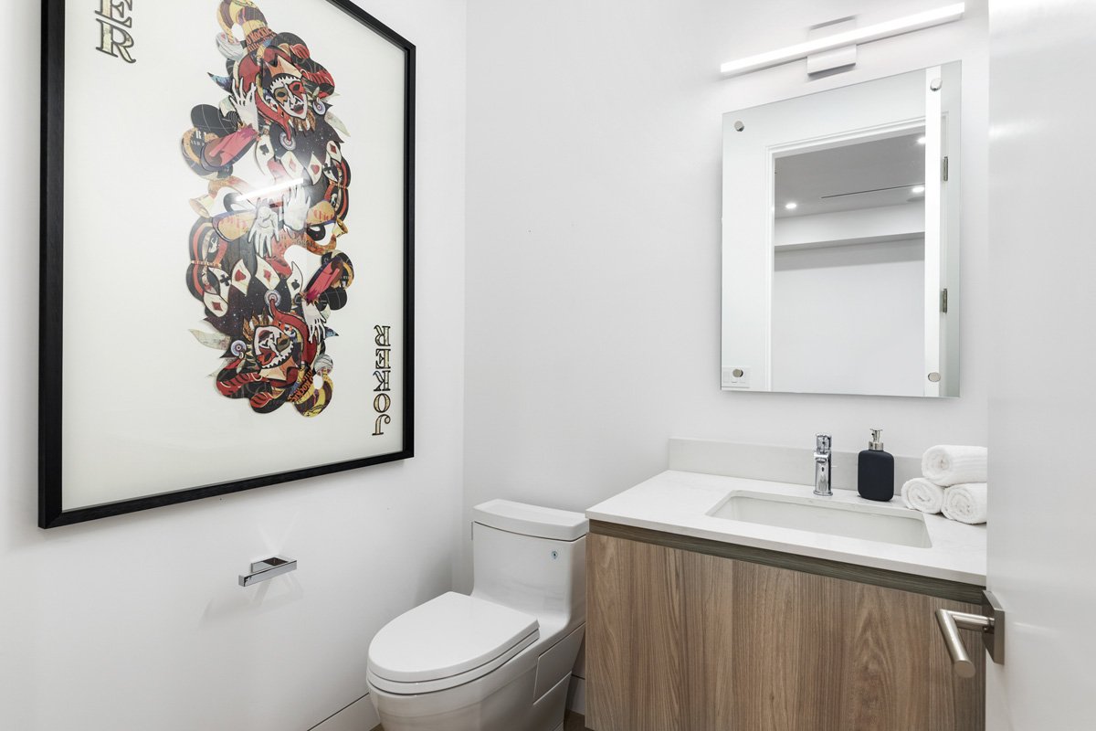 Beverly Hills powder room with floating wood vanity, integrated sink, and framed contemporary artwork