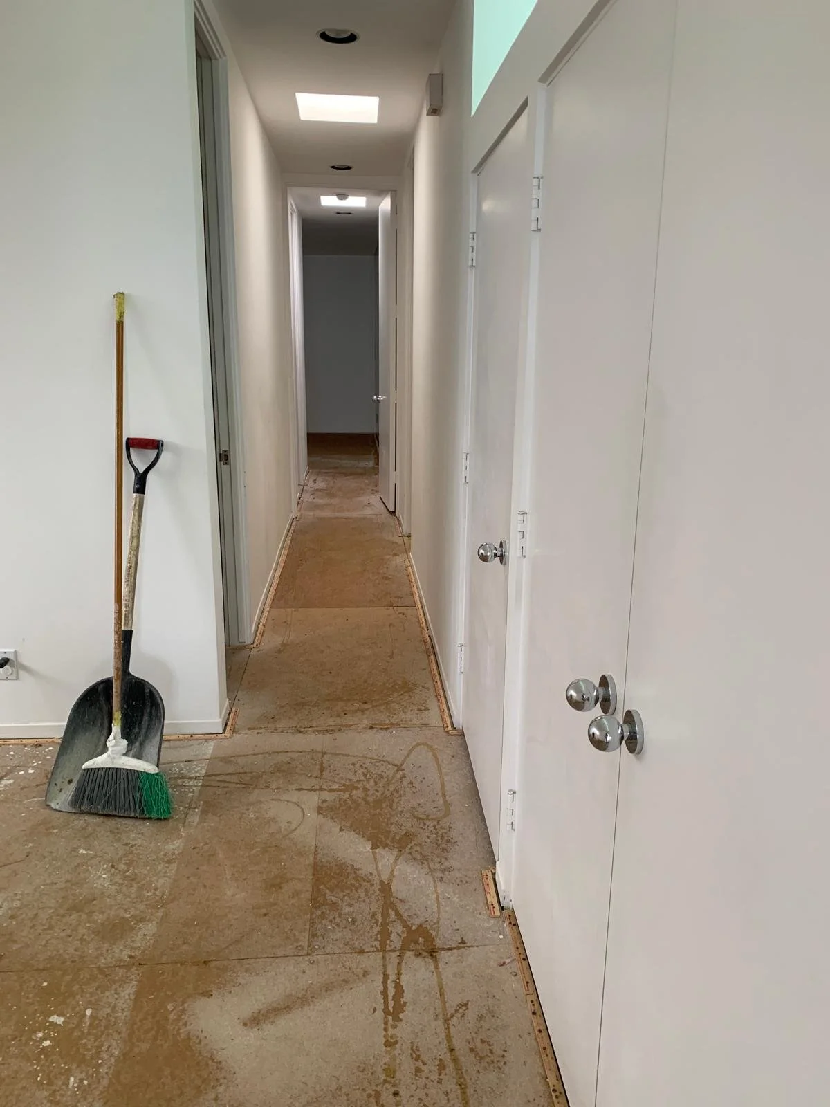 Malibu condo hallway before renovation with stripped flooring, narrow layout, and original interior configuration prior to full gut remodel