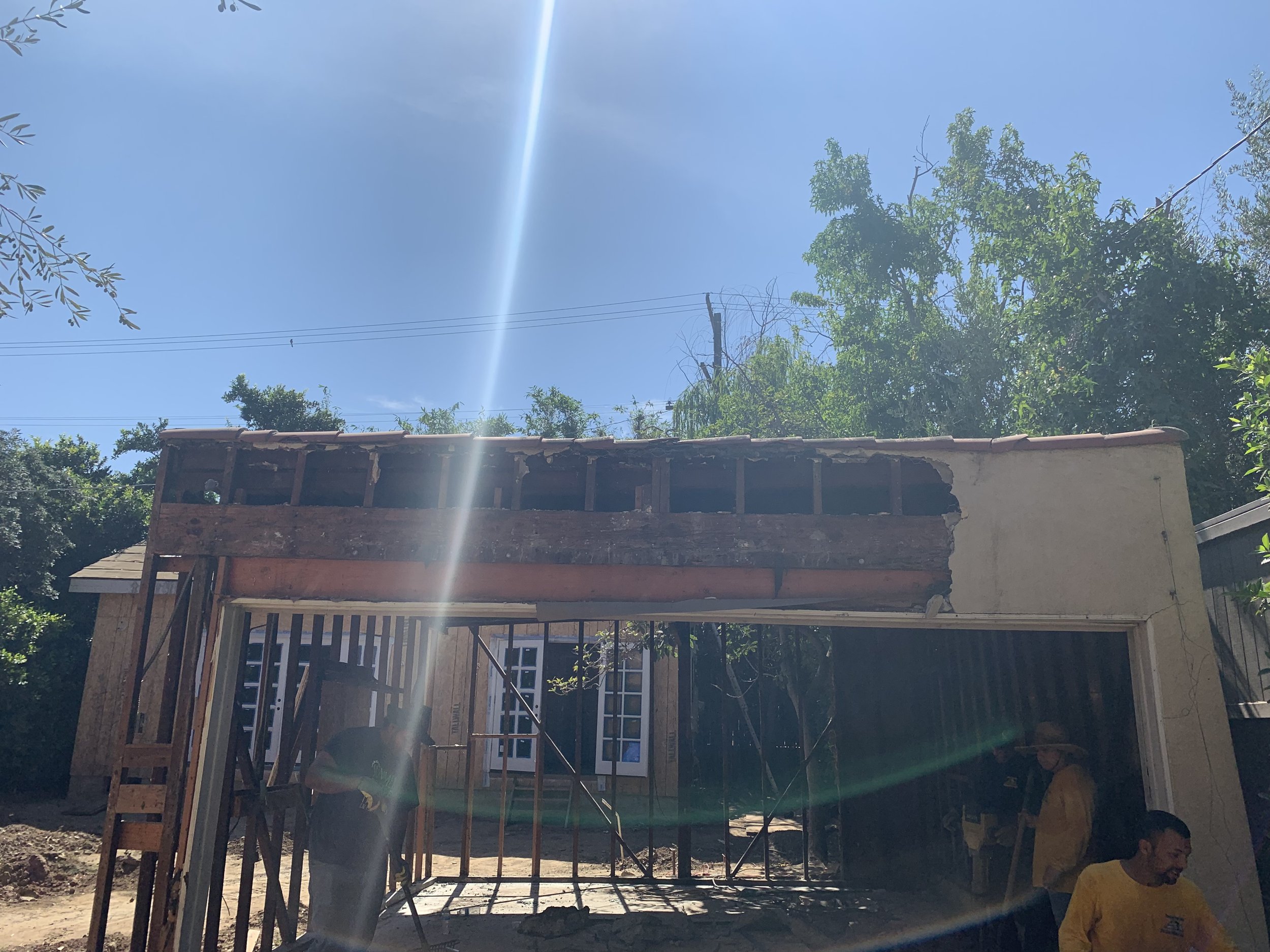 Hancock Park property before renovation with partially demolished garage structure and exposed framing during early construction phase