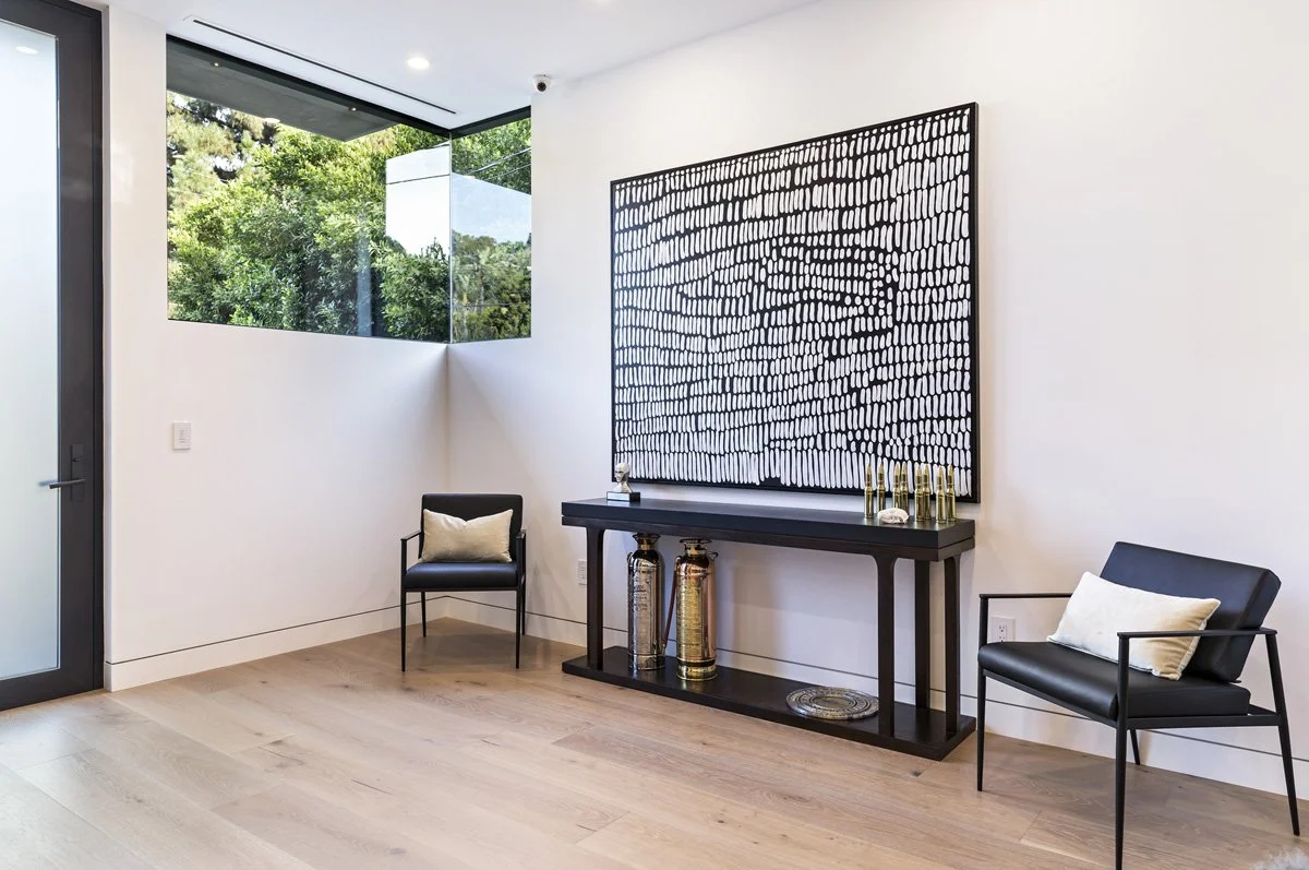 Beverly Hills foyer with corner window, wide-plank oak floors, and modern console table