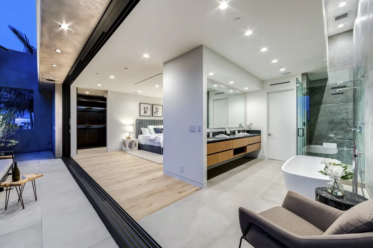 Modern West Hollywood primary suite with spa bathroom and retractable glass wall opening to terrace
