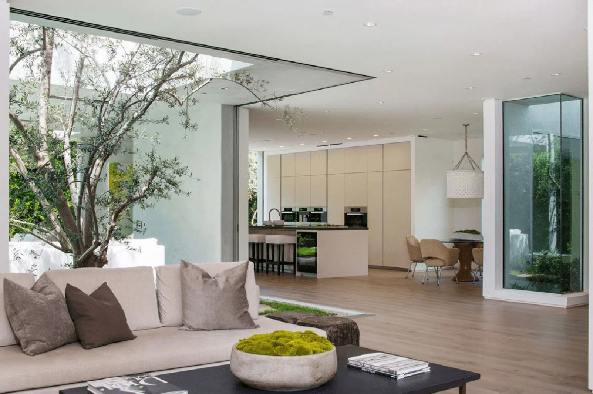 Modern living room in West Hollywood residence with indoor-outdoor connection to garden terrace.