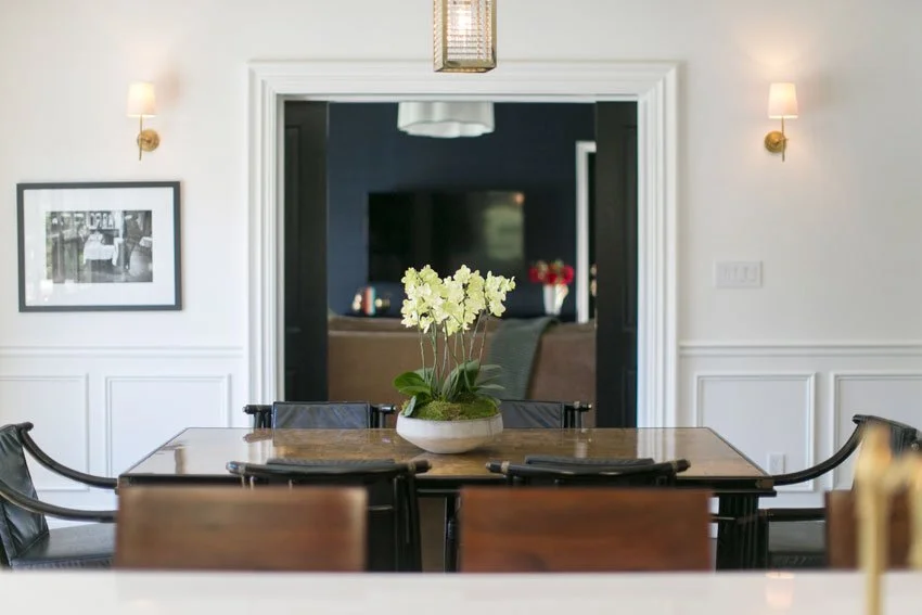 Formal dining room in Hancock Park remodel with wood table, leather chairs, and view to family room