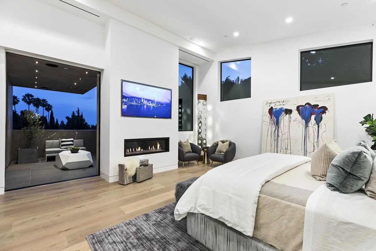 Beverly Hills primary bedroom with fireplace, terrace access, and wide-plank oak flooring