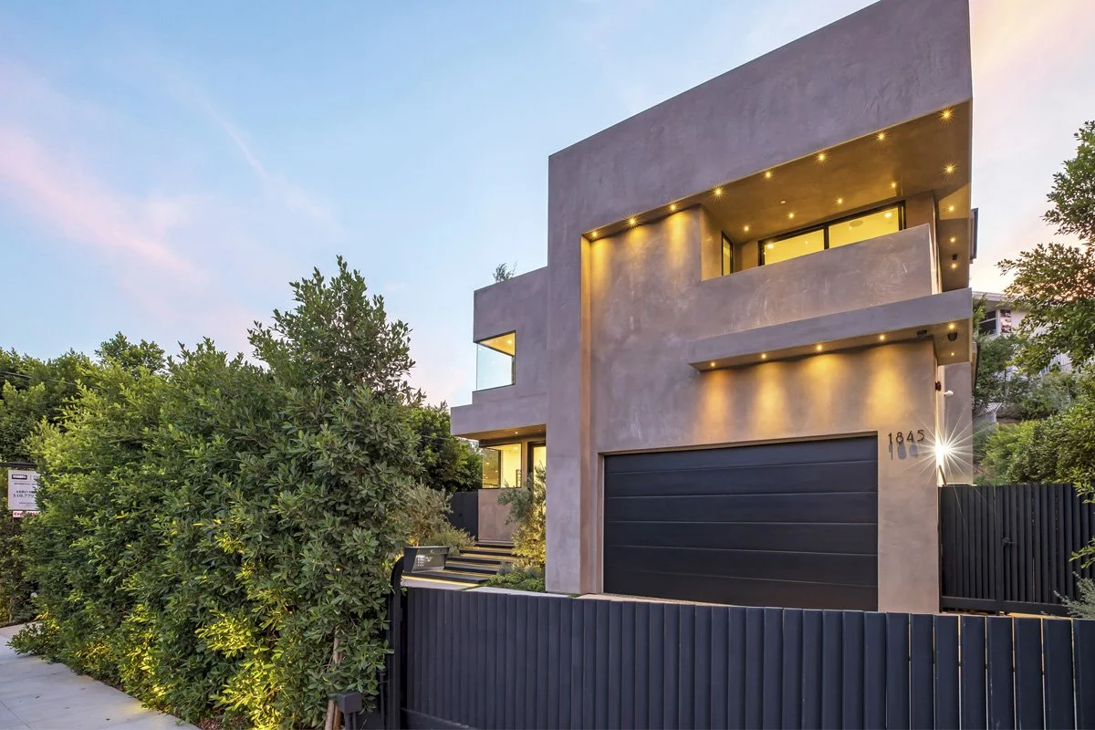 Beverly Hills contemporary home exterior at dusk with smooth plaster façade and modern driveway