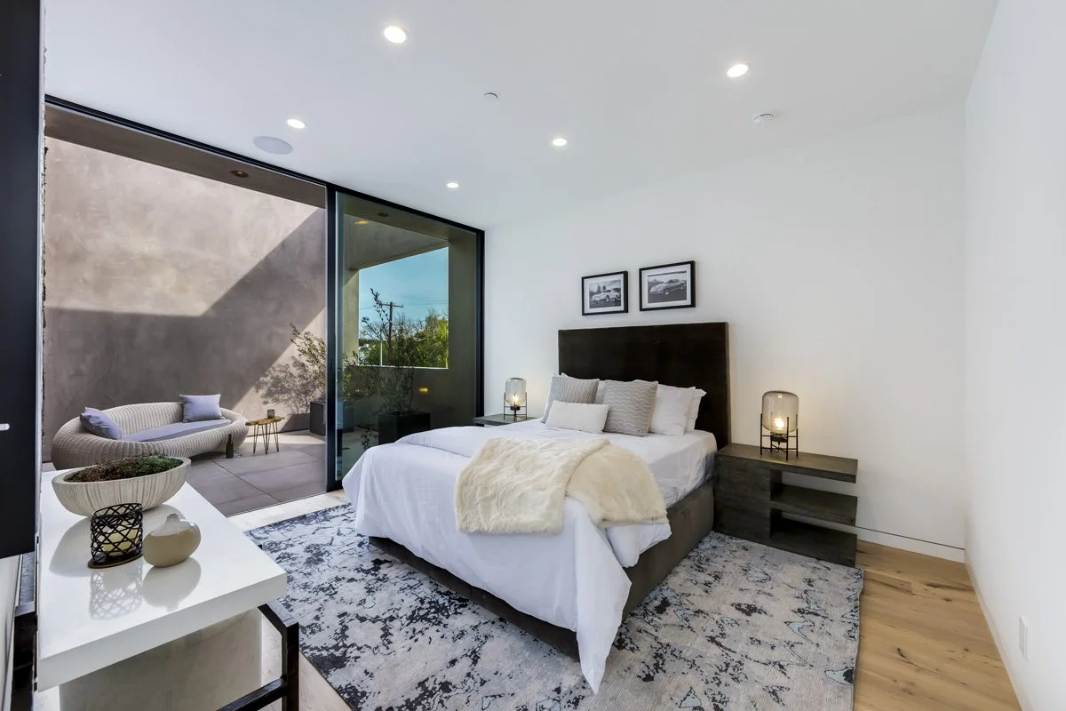 West Hollywood custom home primary bedroom with private balcony and floor-to-ceiling sliding glass doors