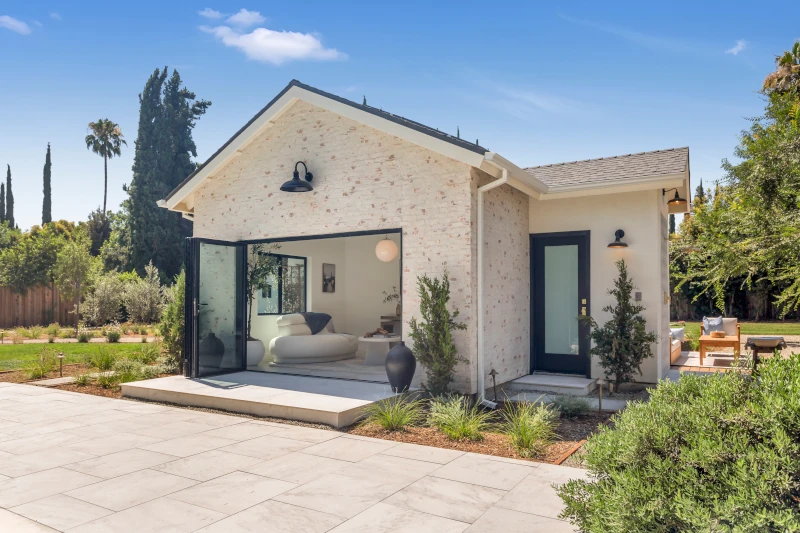 Detached ADU in Los Angeles with brick exterior and open folding glass doors to private patio.