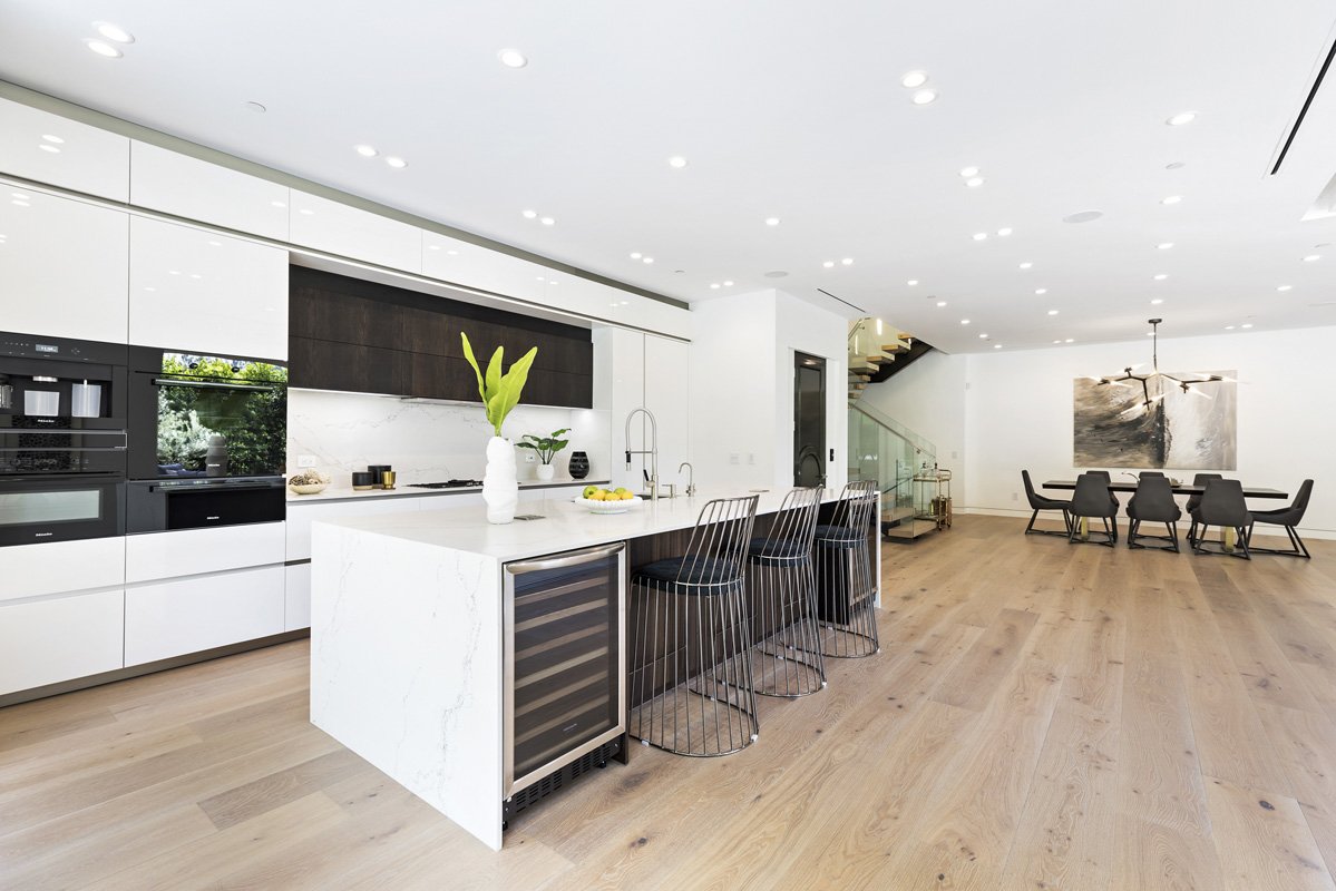 Beverly Hills open-concept kitchen and dining space with floating staircase and modern chandelier