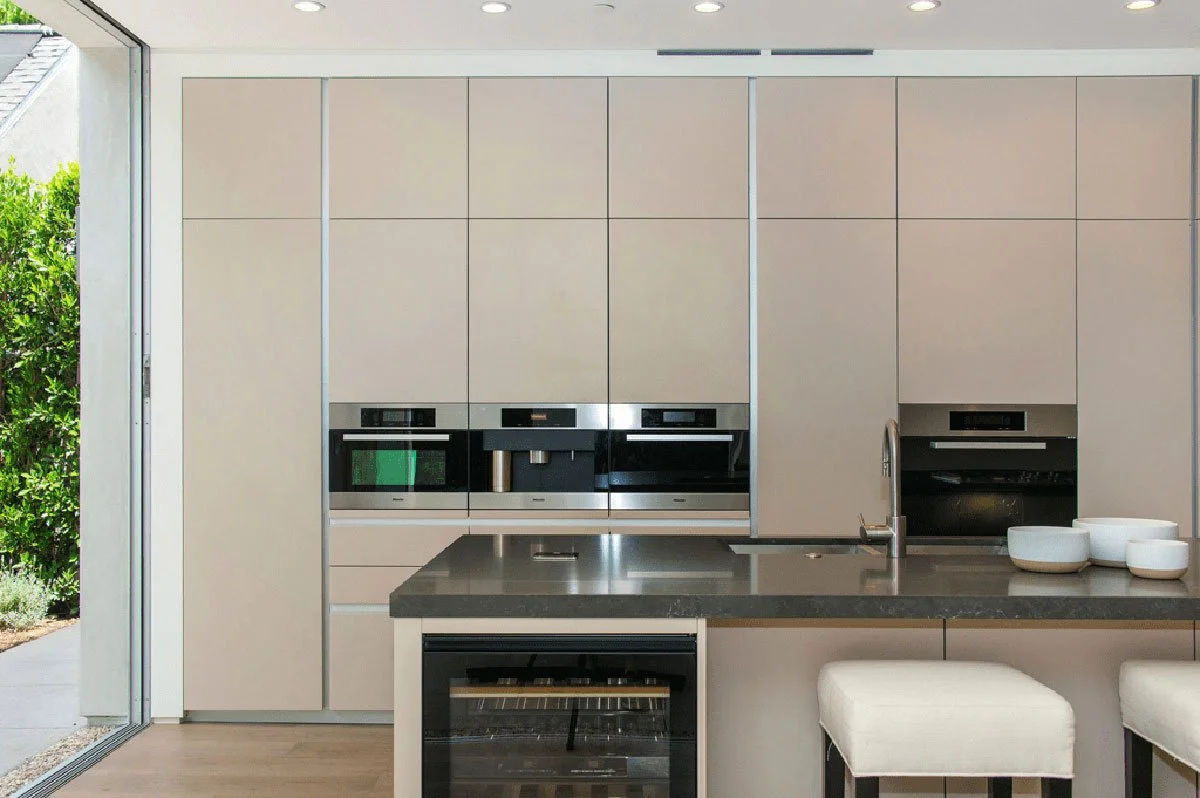 Minimalist kitchen wall with integrated appliances and cabinetry in West Hollywood custom residence.