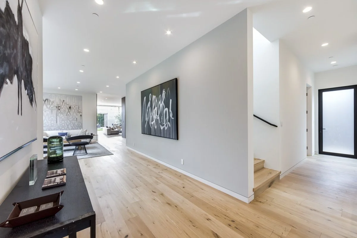 West Hollywood custom home entry hallway with wide-plank oak floors and open-plan living beyond