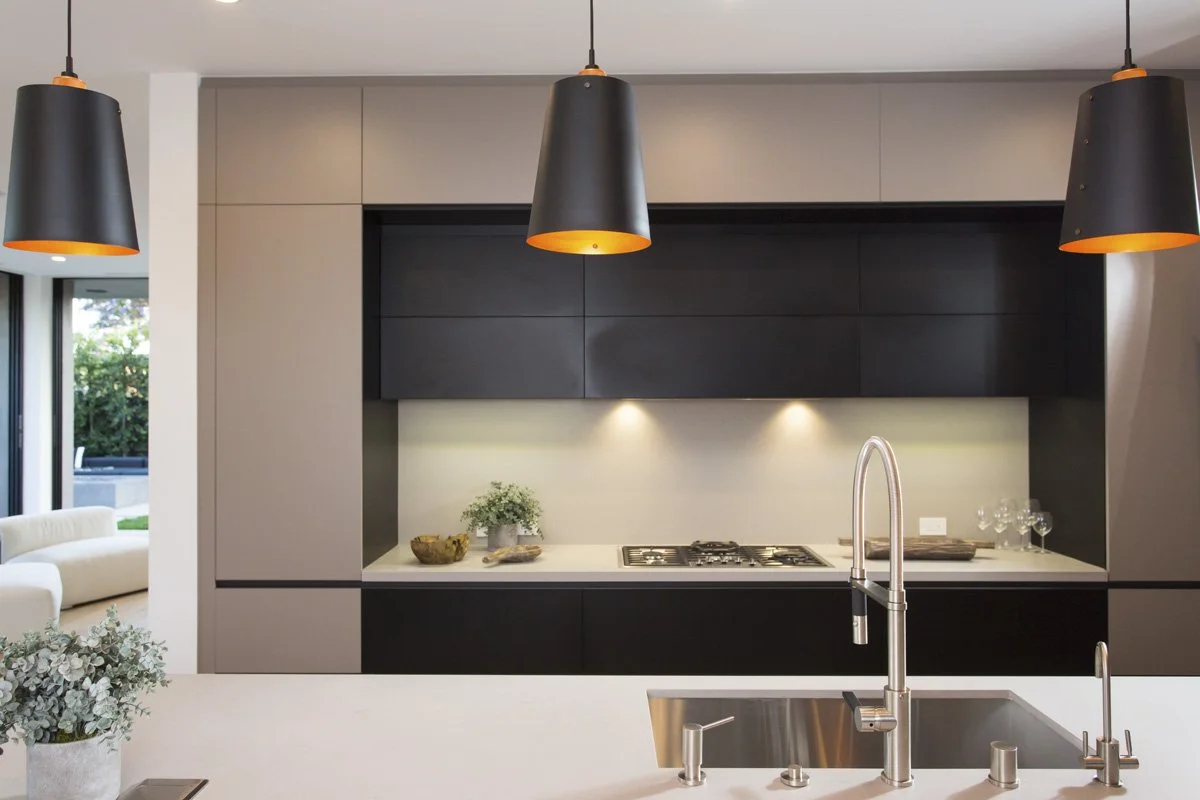 Venice modern kitchen wall detail with matte flat-panel cabinetry, integrated gas cooktop, under-cabinet lighting, and minimalist backsplash