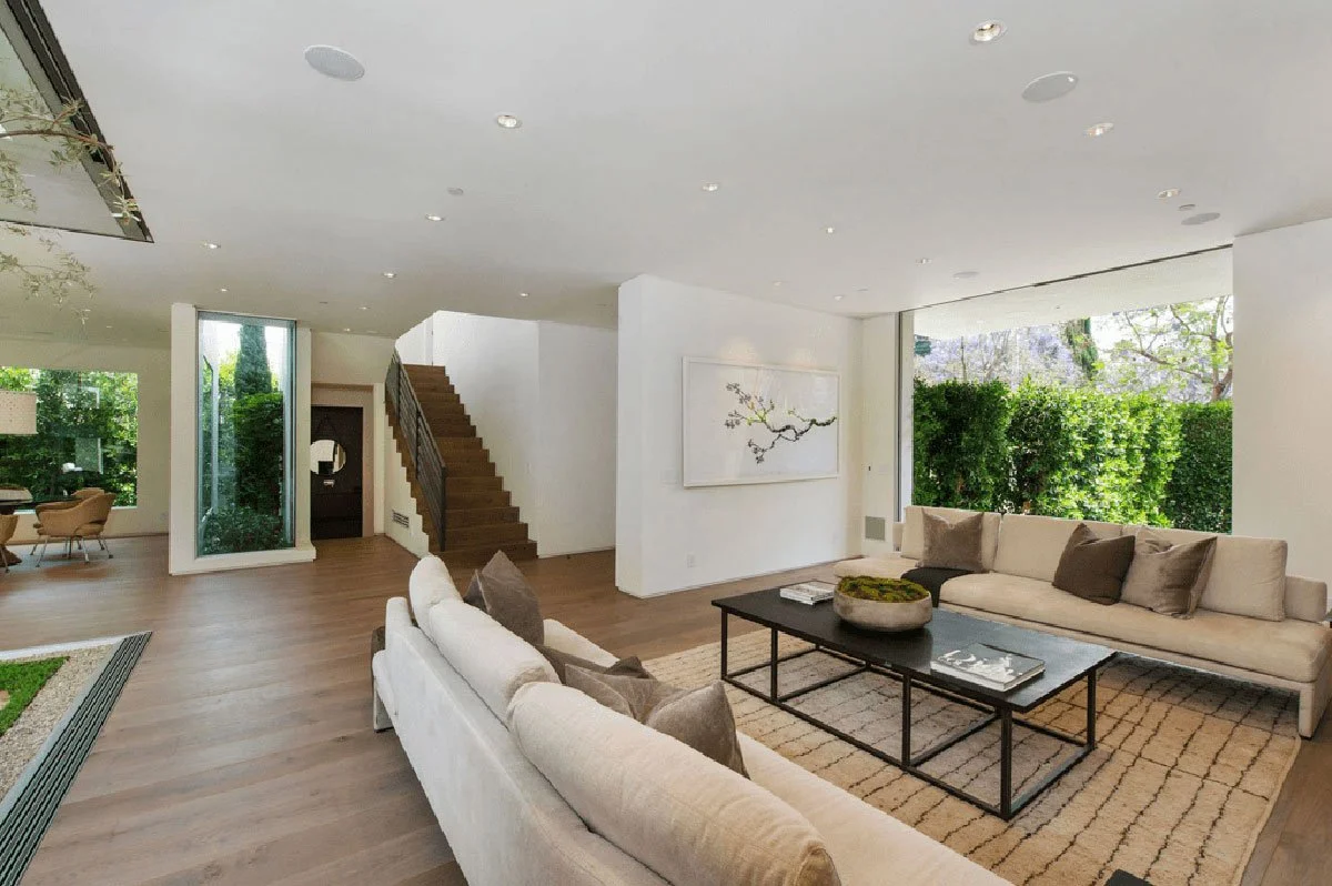 Bright open living room in West Hollywood custom home with staircase and courtyard views.