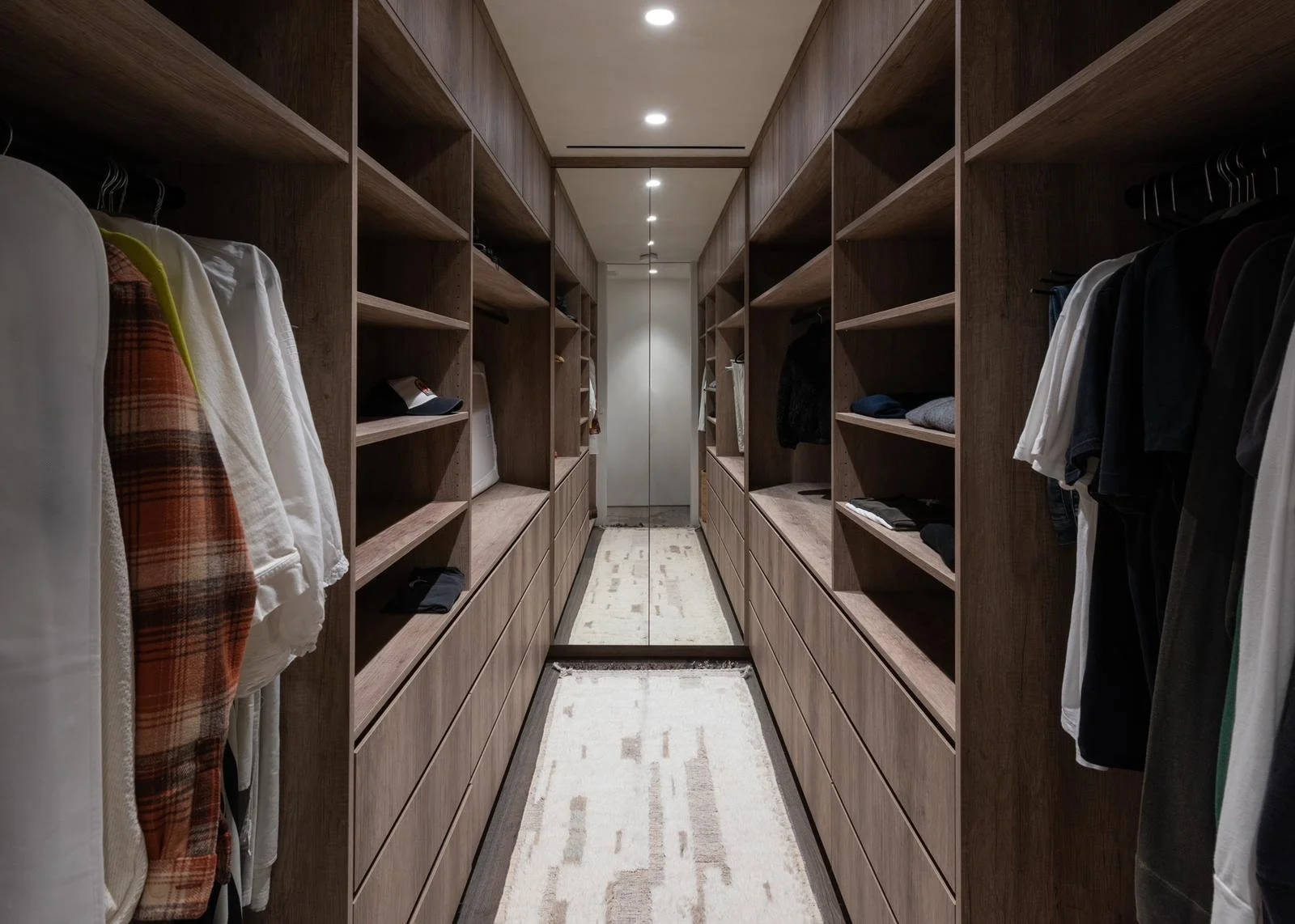 Custom walk-in closet in Malibu home with built-in wood shelving and drawers.