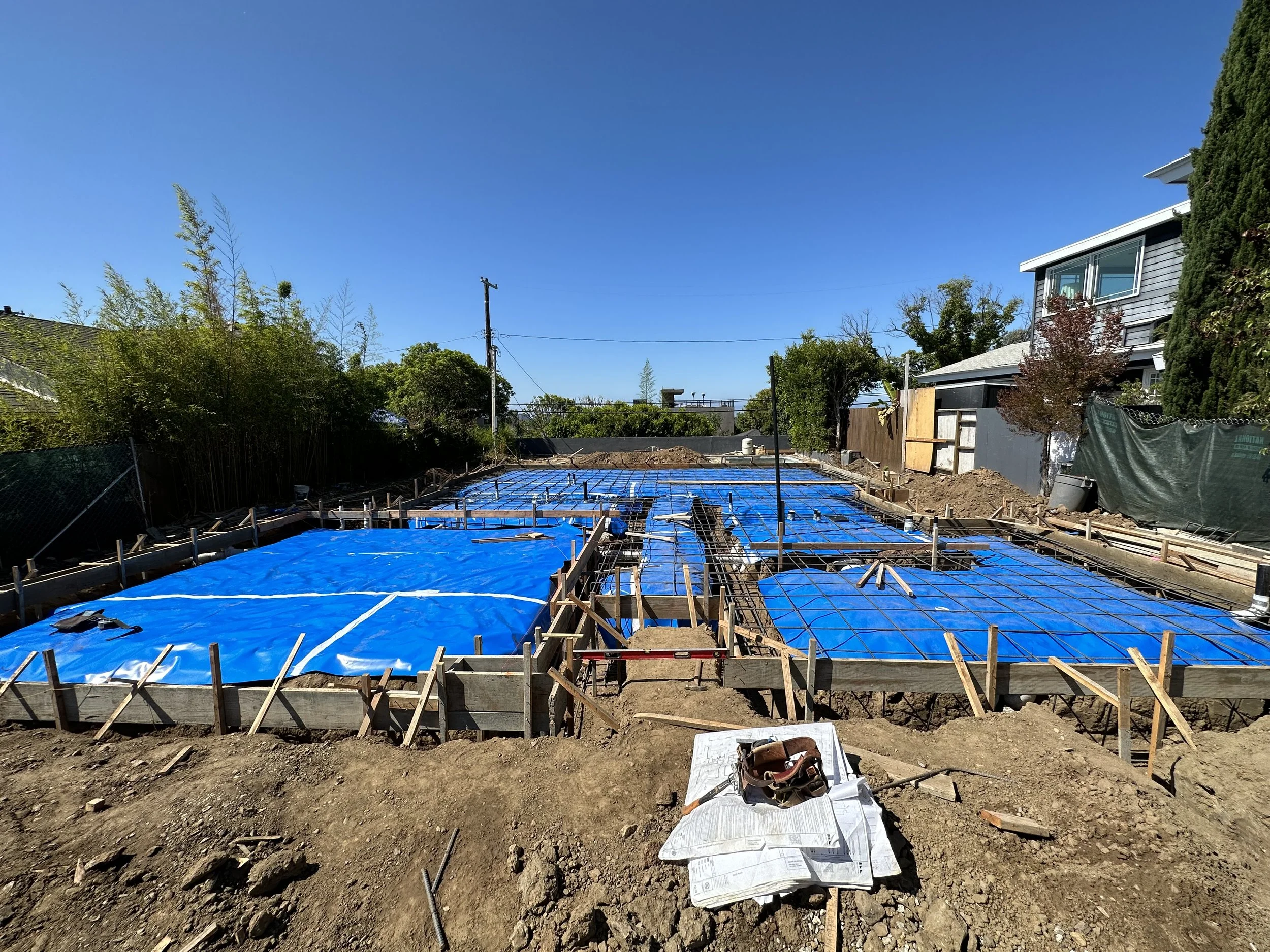Foundation layout with formwork, rebar, and moisture barrier installed for custom home construction