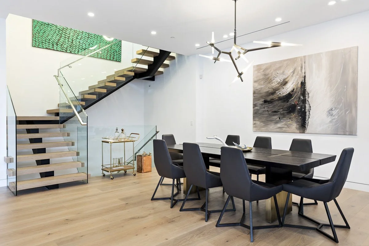 Beverly Hills open-concept dining room with floating wood staircase and sculptural chandelier