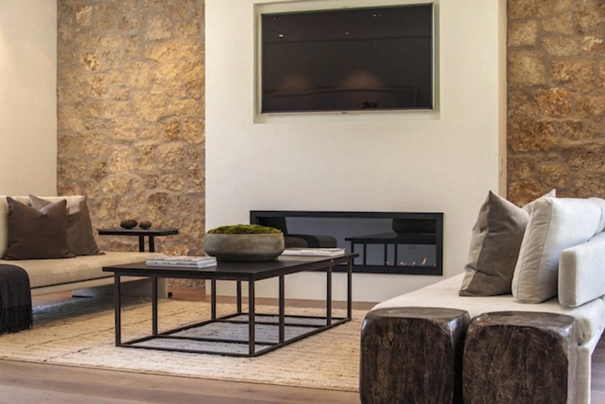 Modern living room in West Hollywood custom home with stone accent walls and linear fireplace.