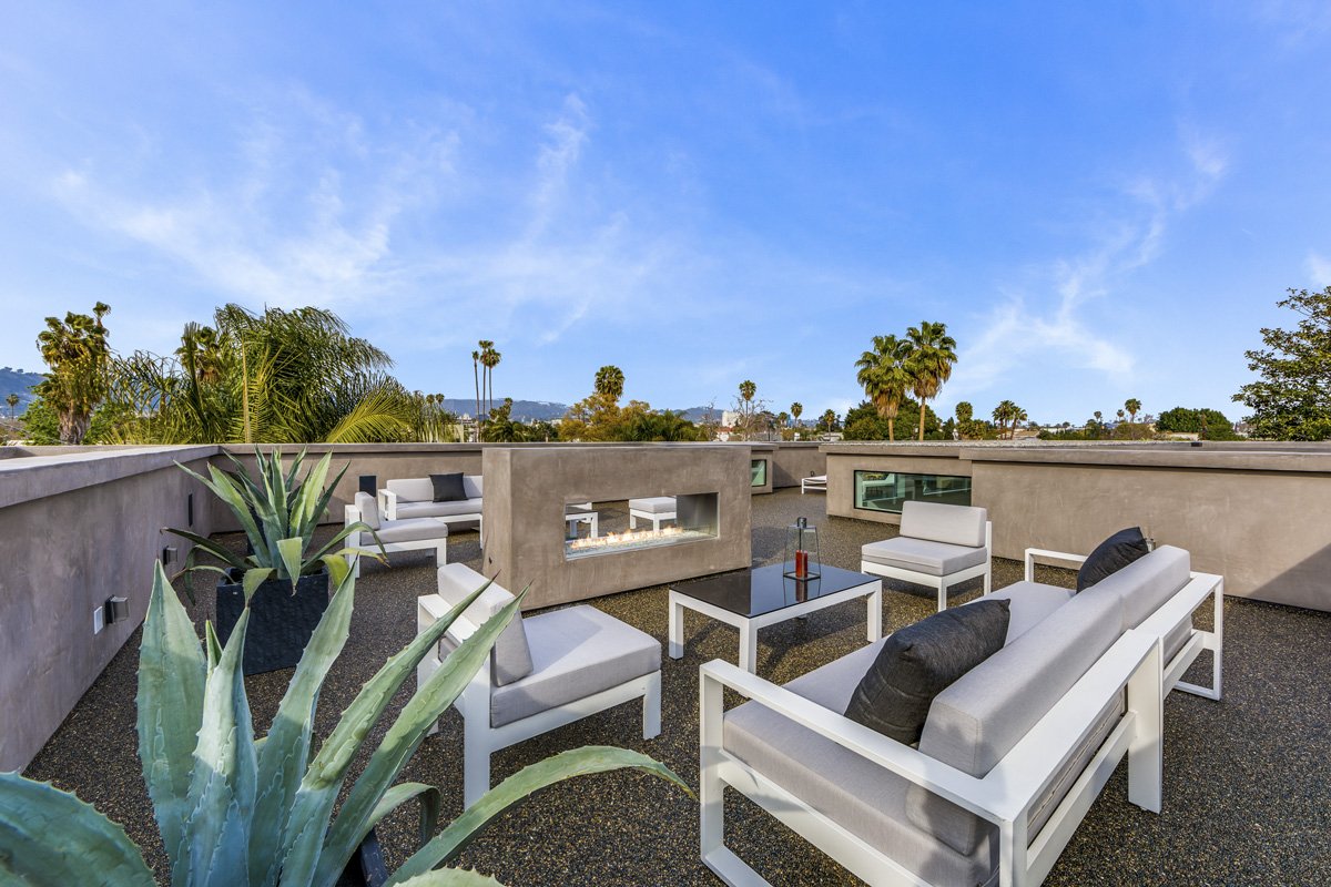 Modern rooftop terrace with built-in fire feature and city skyline views