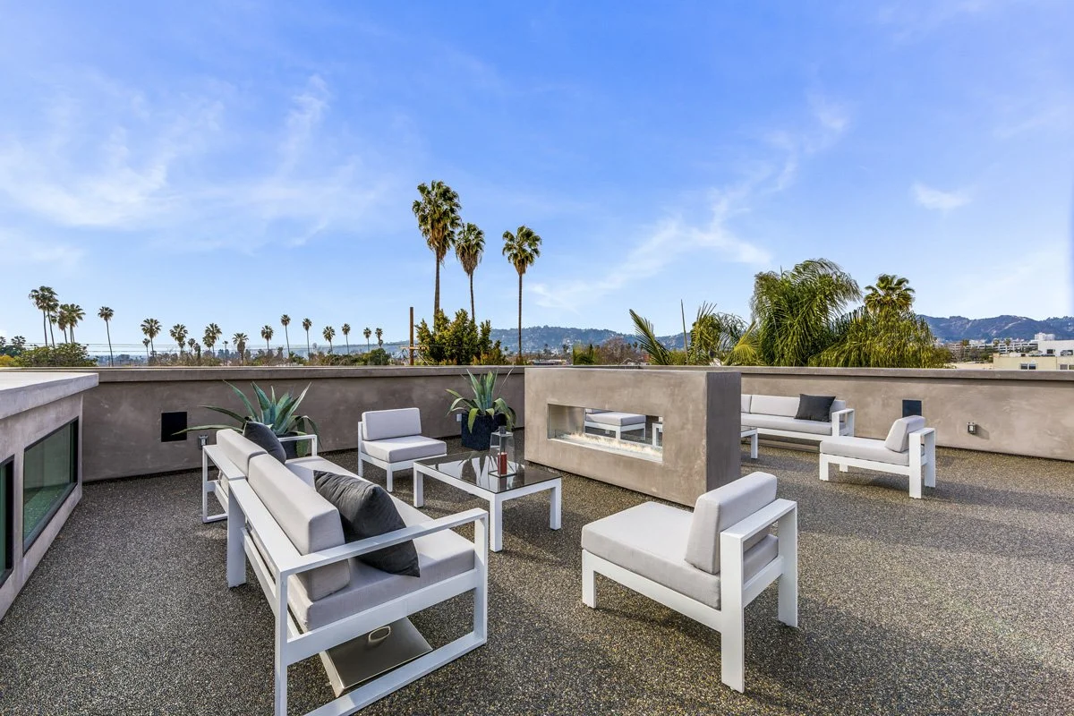 Modern rooftop terrace with built-in fire feature and Los Angeles skyline views