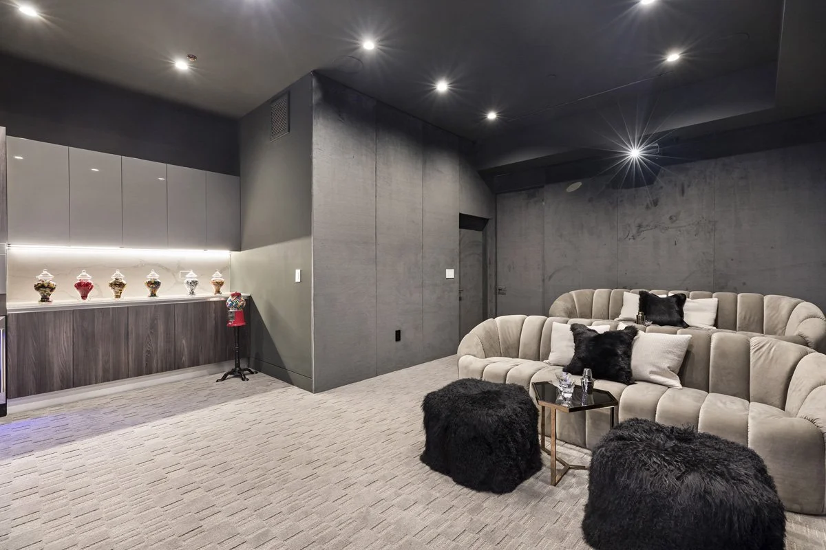 Beverly Hills entertainment lounge with curved seating, recessed ceiling lighting, and concrete feature walls