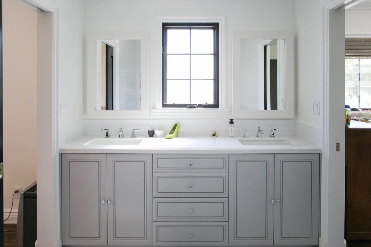 Double vanity bathroom with white cabinetry, twin mirrors, and central window in Hancock Park remodel