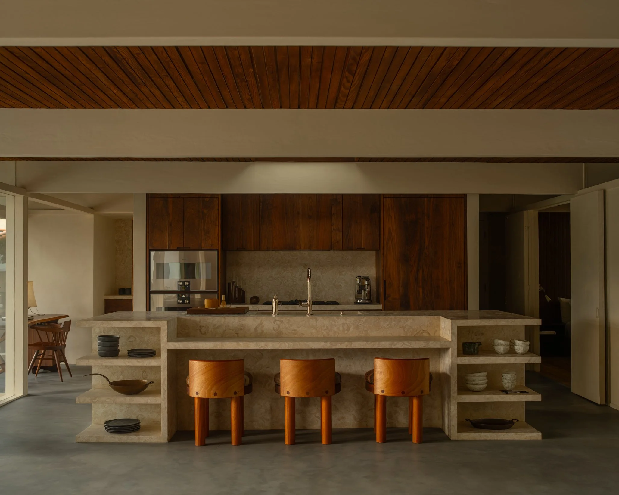 Kitchen remodel in Los Angeles featuring a custom stone island, warm wood cabinetry, integrated appliances, and modern craftsmanship by Heart Construction.