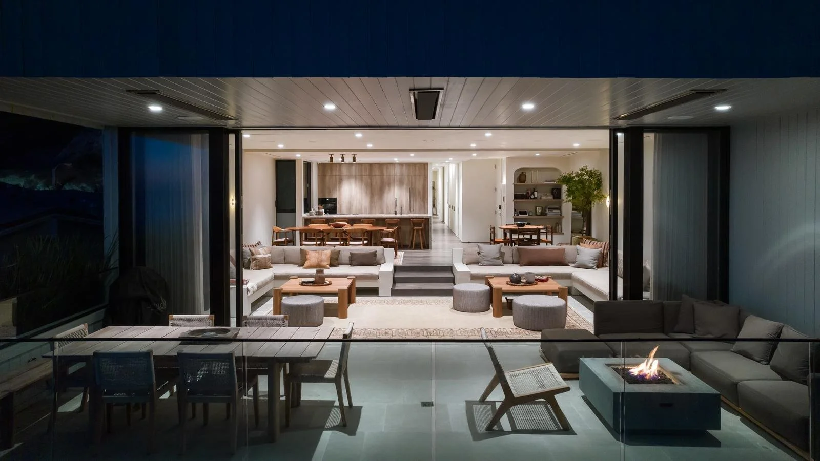 Open-concept Malibu oceanfront living area with sliding glass walls and seamless indoor-outdoor design.