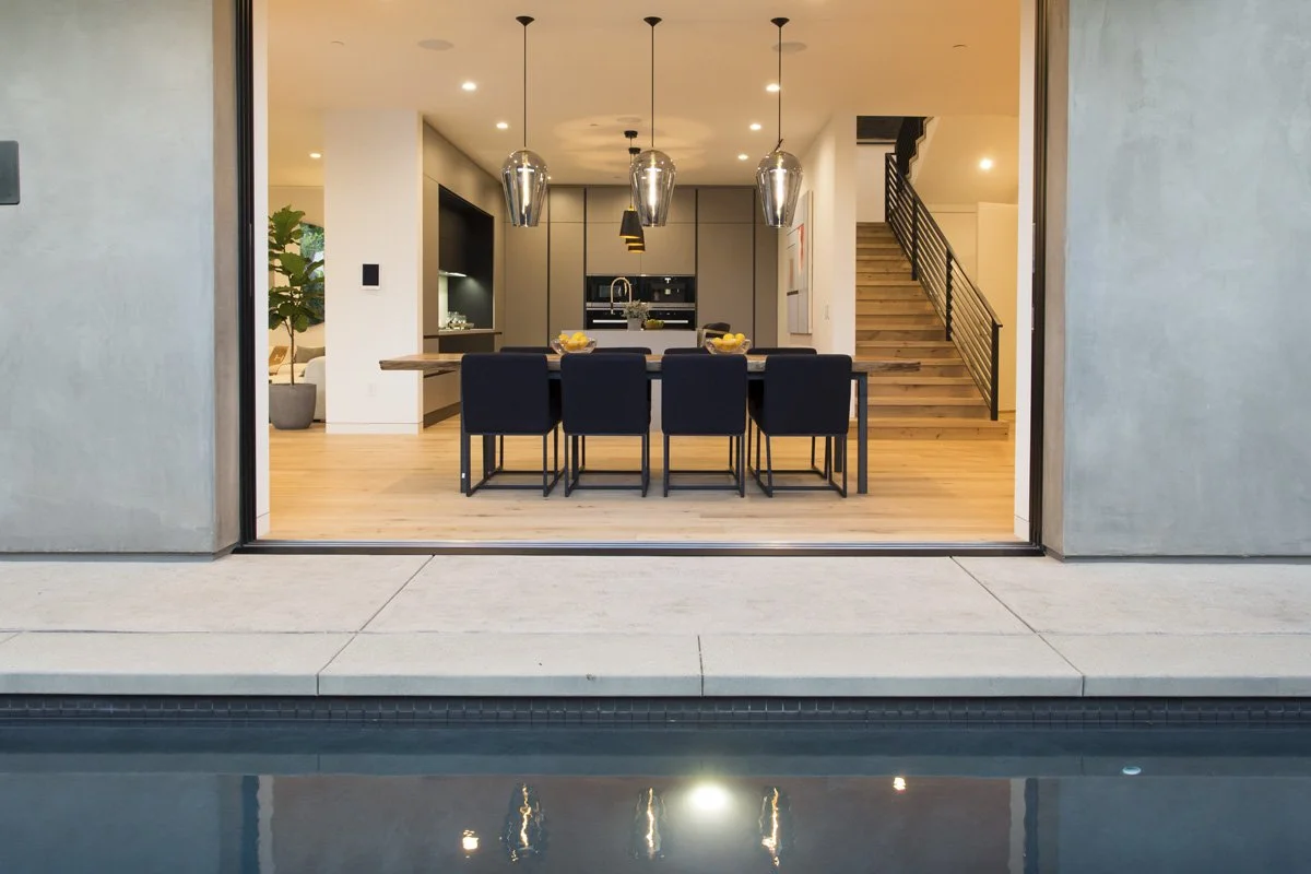 Indoor-outdoor dining area opening to pool in contemporary Venice custom home
