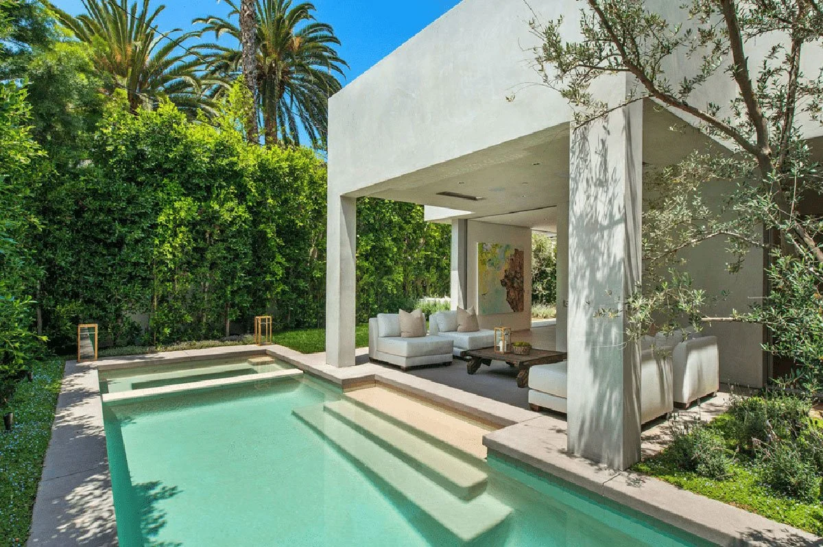 Backyard pool with covered patio lounge and palm trees in West Hollywood modern residence.