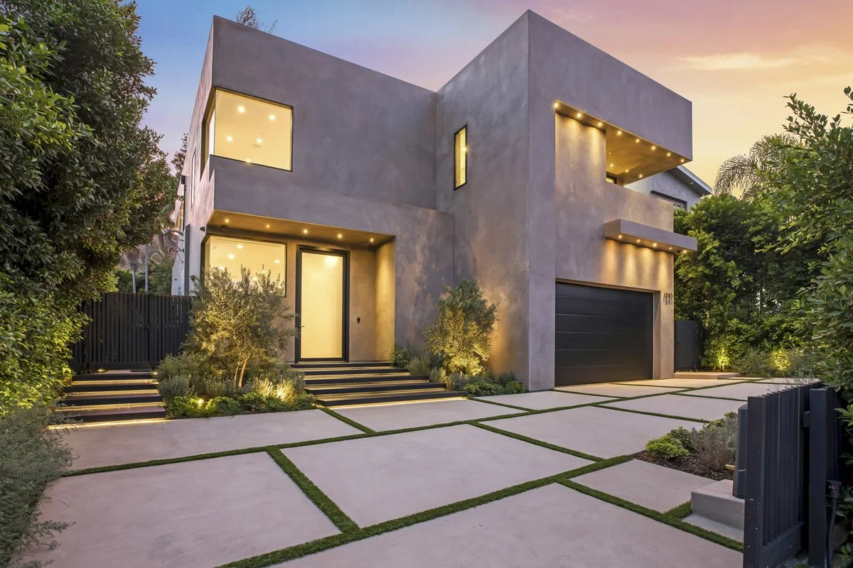 Beverly Hills modern front elevation at sunset with integrated landscape lighting and black garage door