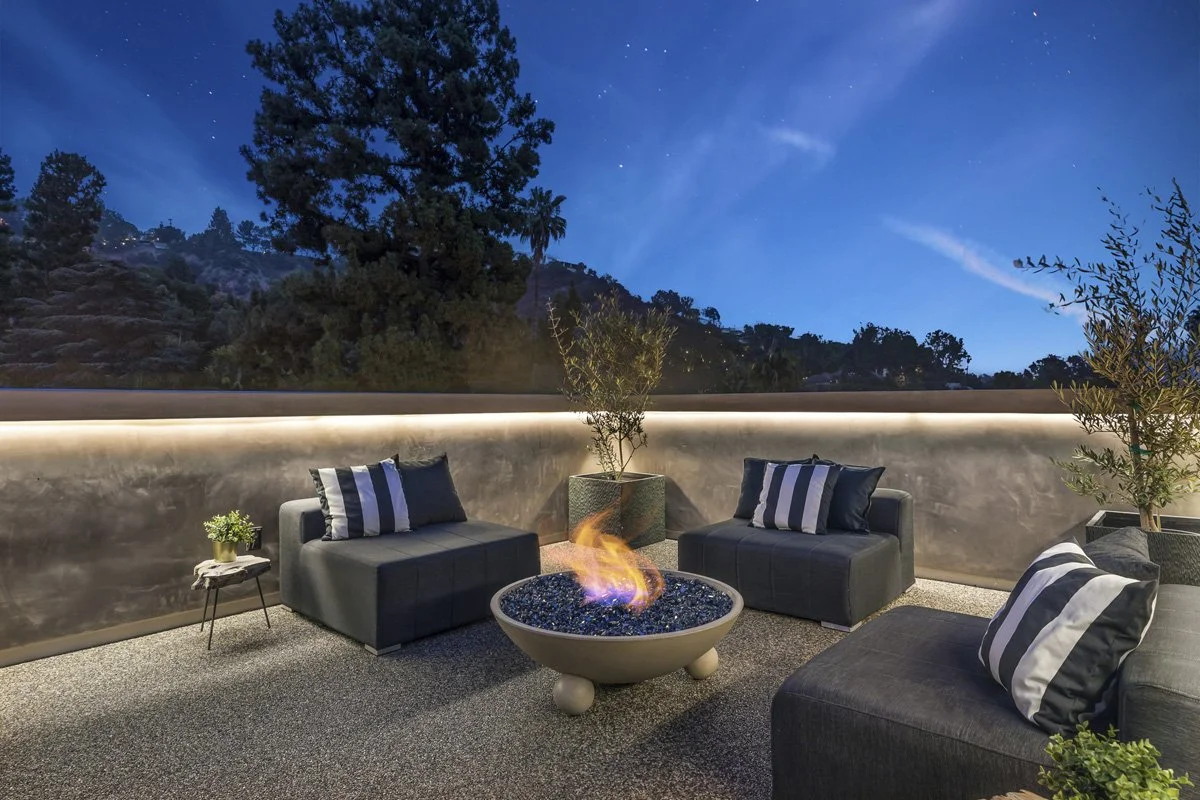 Beverly Hills rooftop fire feature with lounge seating and illuminated landscape backdrop at dusk