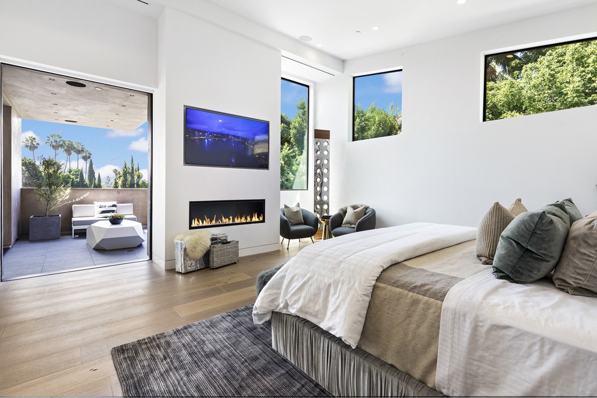 Beverly Hills primary bedroom with linear fireplace and private terrace access