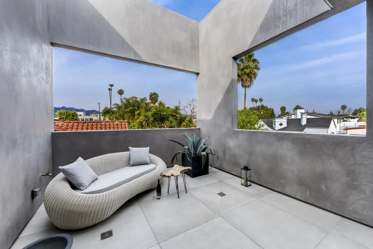 West Hollywood custom home private balcony with concrete walls and city skyline views