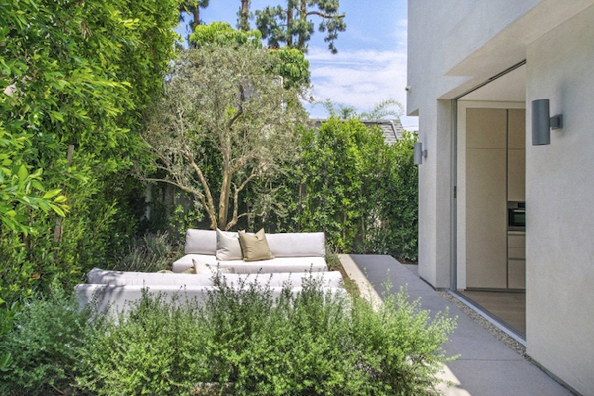 Garden courtyard seating area in West Hollywood modern home with lush landscaping and sliding glass doors