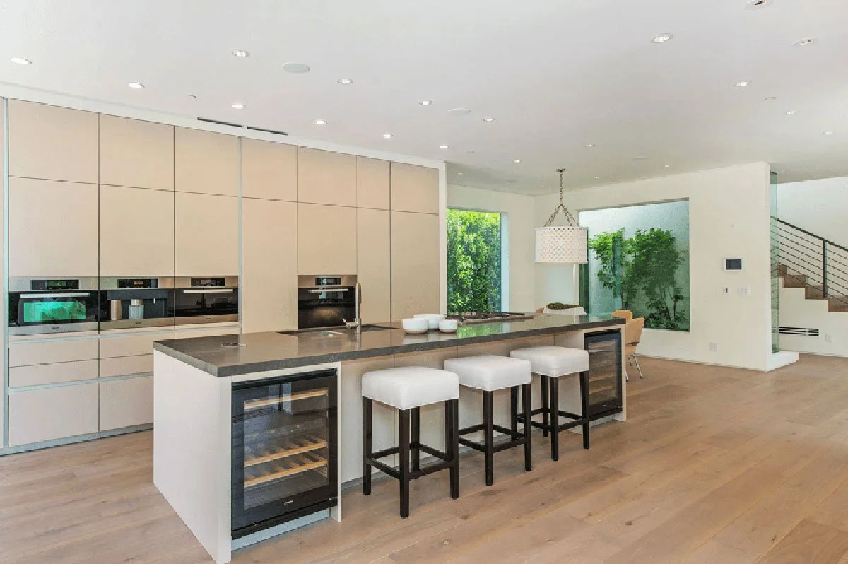 Modern kitchen with large island seating and integrated cabinetry in a West Hollywood courtyard custom home
