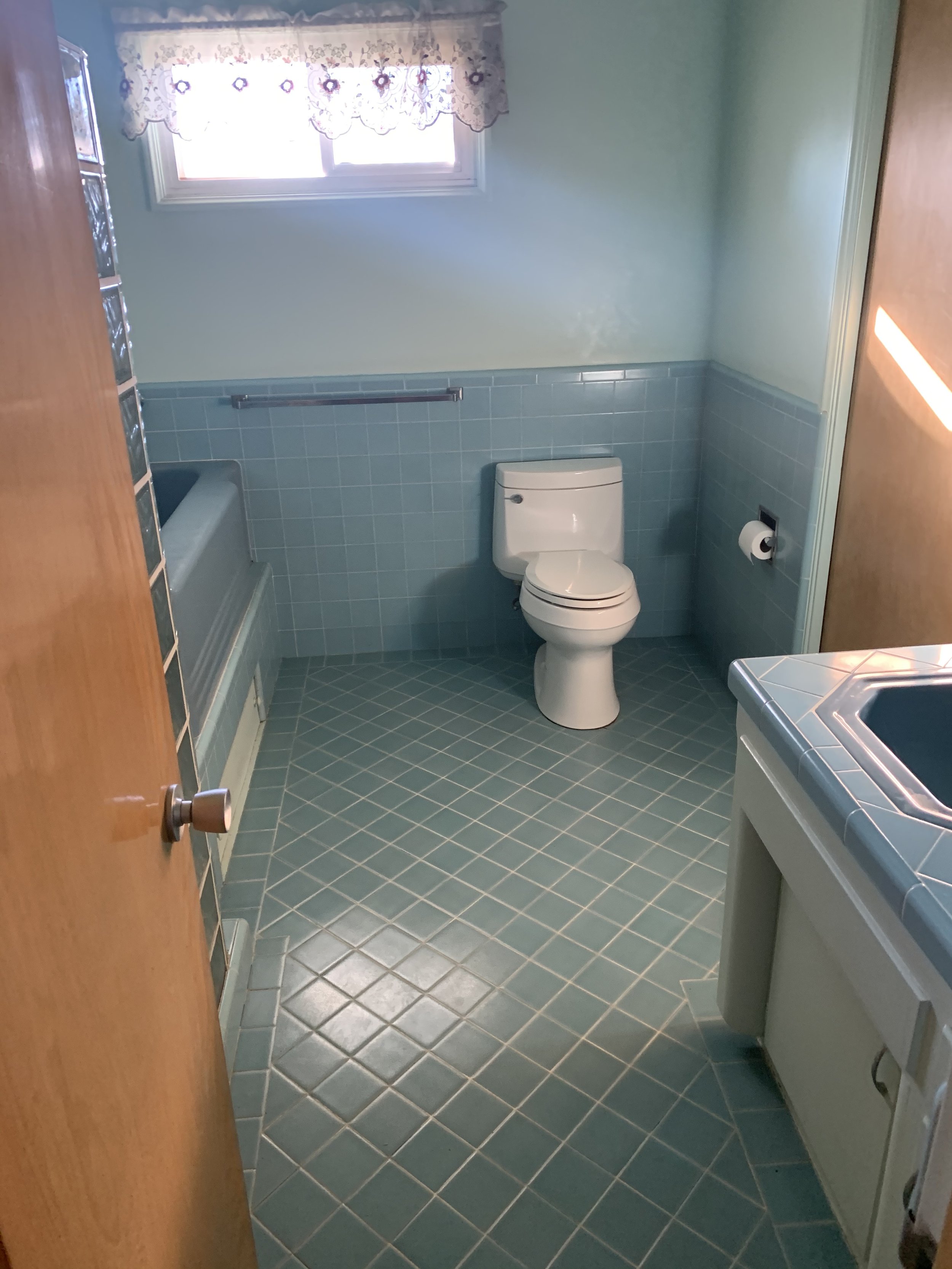 Culver City bathroom before renovation with original blue tile, built-in tub, and outdated layout