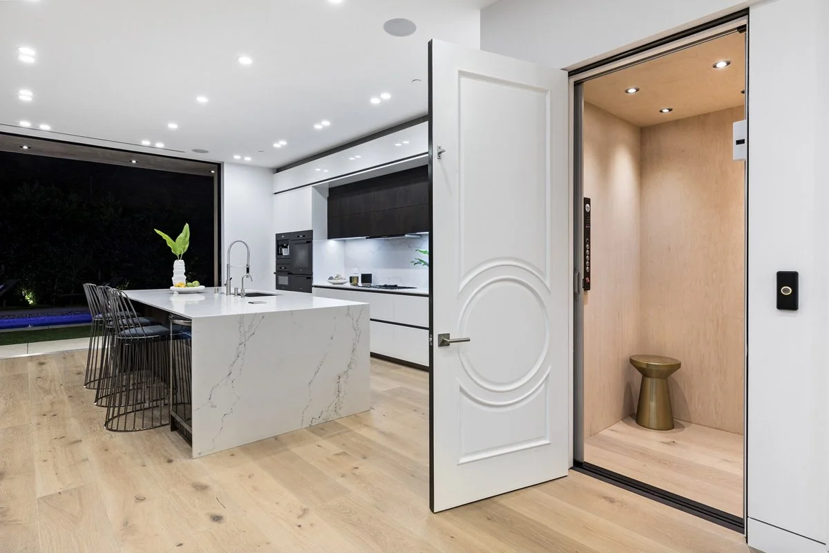 Beverly Hills modern kitchen with waterfall quartz island and integrated residential elevator