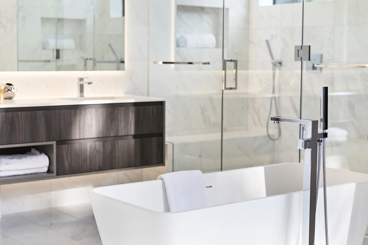 Beverly Hills primary bathroom vanity with walnut cabinetry, integrated lighting, and glass shower enclosure