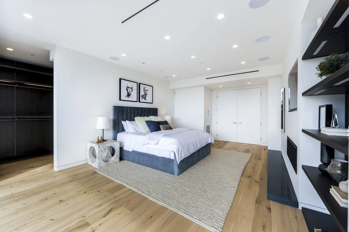 West Hollywood custom home primary bedroom with wide plank oak floors and built-in fireplace