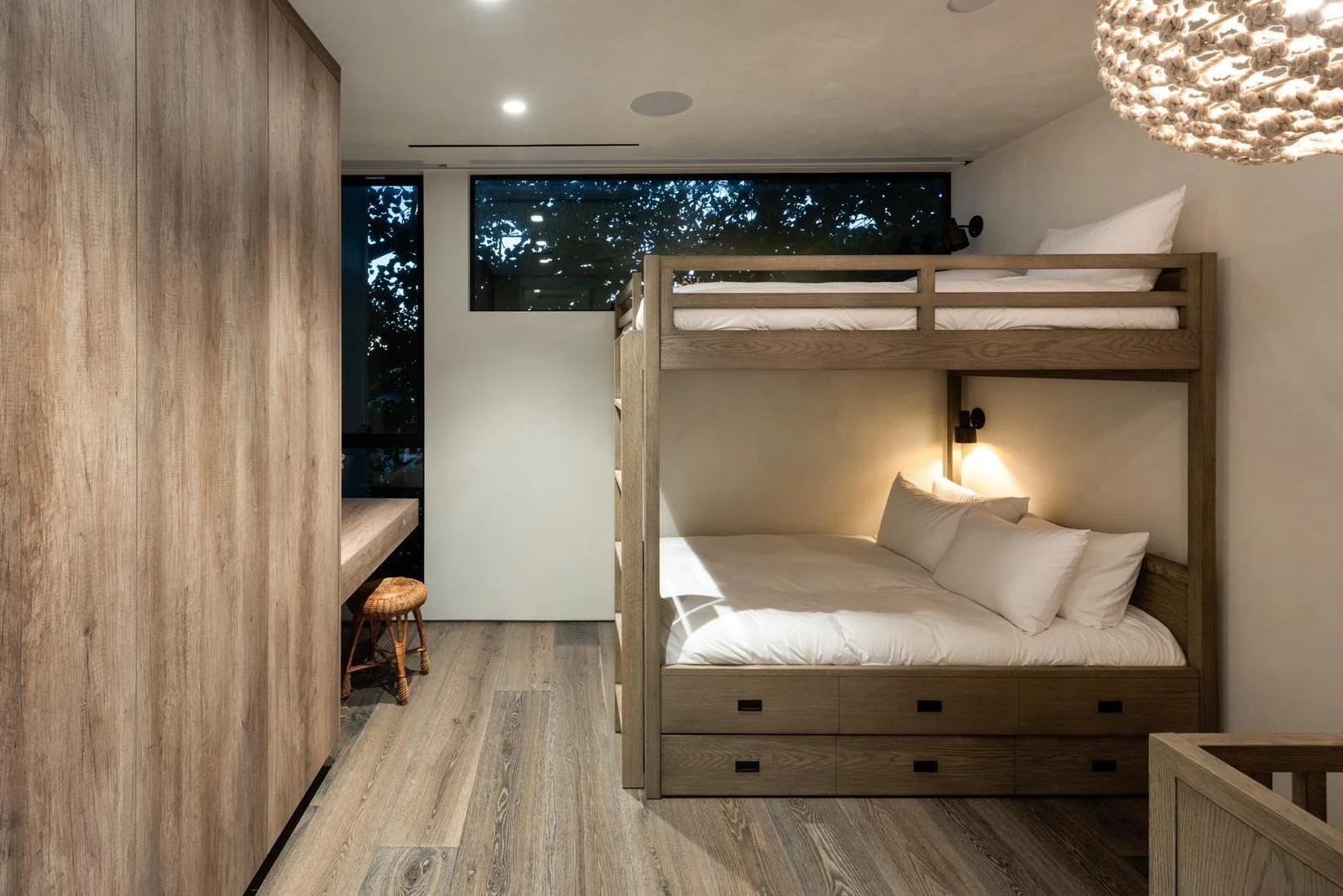 Malibu home bunk bedroom with custom wood built-in beds and storage drawers.