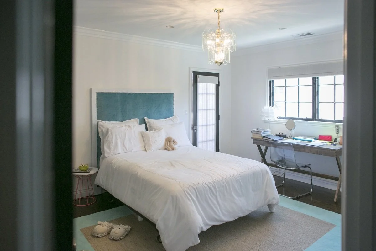 Bedroom with teal upholstered headboard, desk workspace, and natural light in Hancock Park home