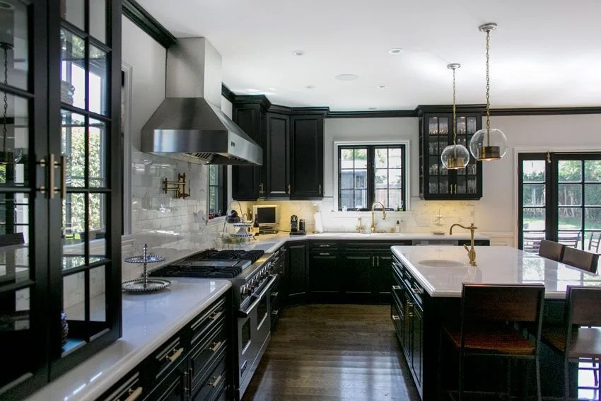 Open kitchen with black cabinetry, marble counters, and large island in Hancock Park home