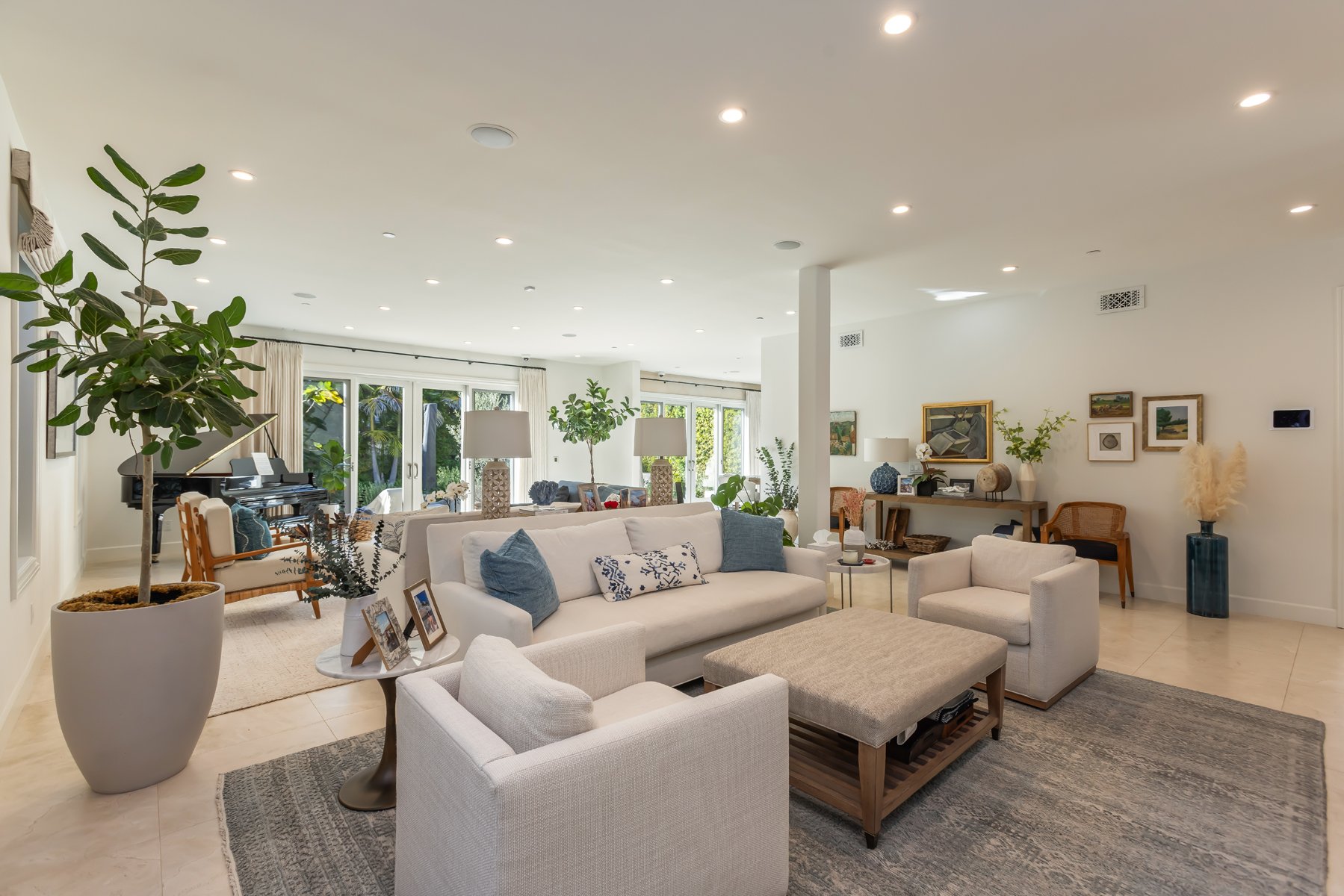 Open-concept Brentwood living room remodel with natural light, neutral furnishings, recessed lighting, and seamless indoor-outdoor flow by Heart Construction.