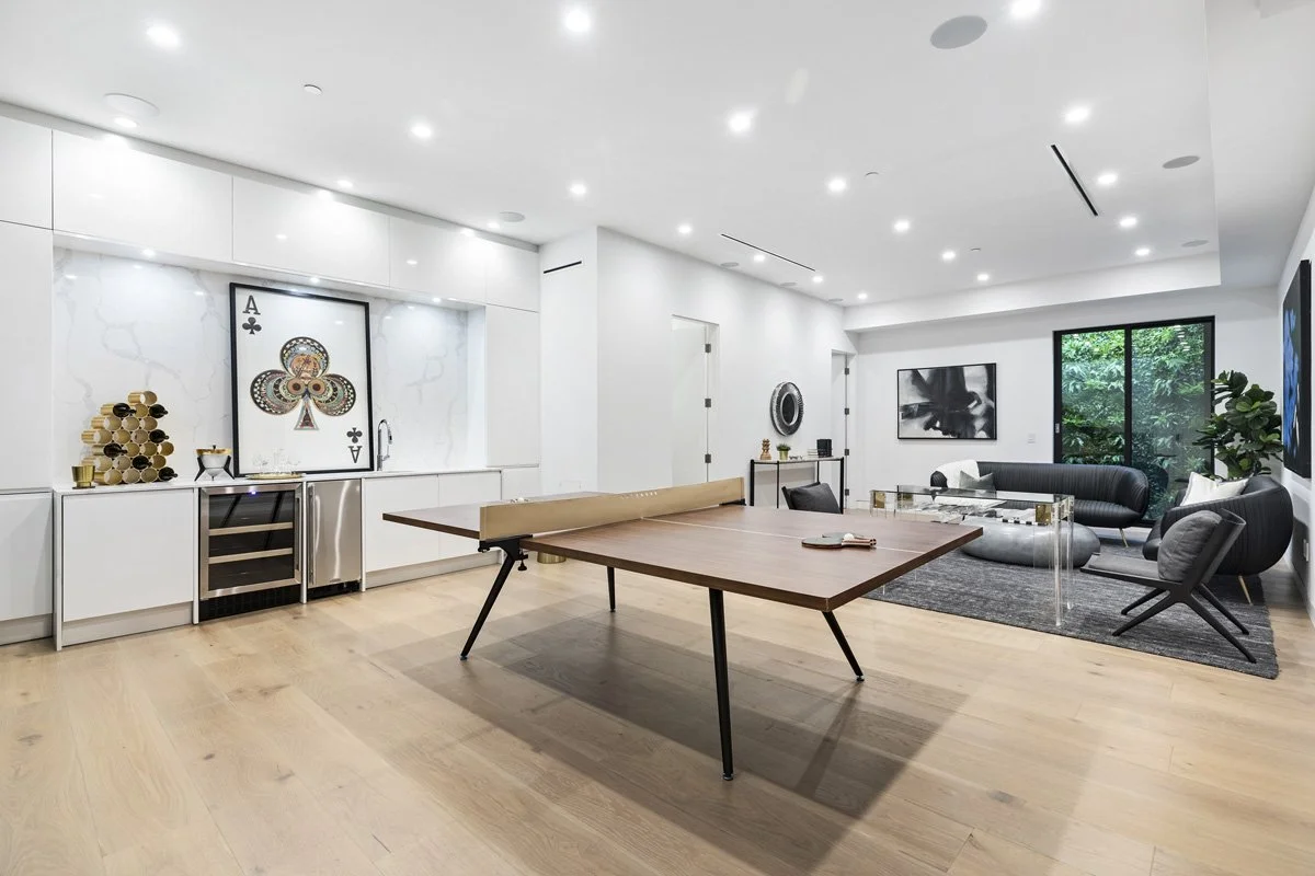 Beverly Hills game room with built-in bar, wine refrigerator, and open lounge seating area