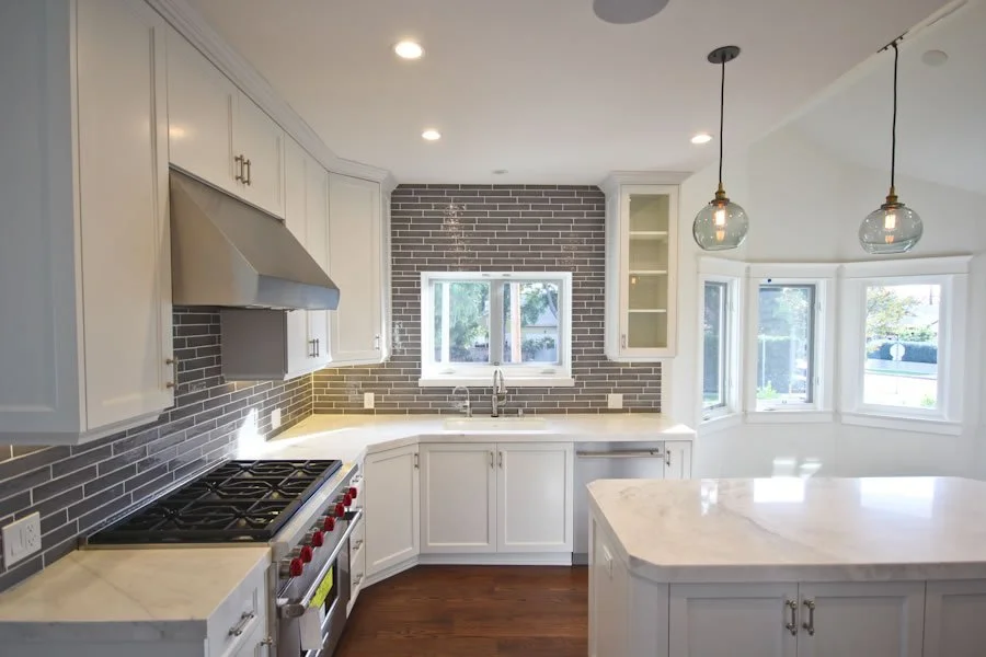 Spaulding Square custom kitchen with white shaker cabinets, gray subway tile backsplash, marble countertops, and center island in Los Angeles.
