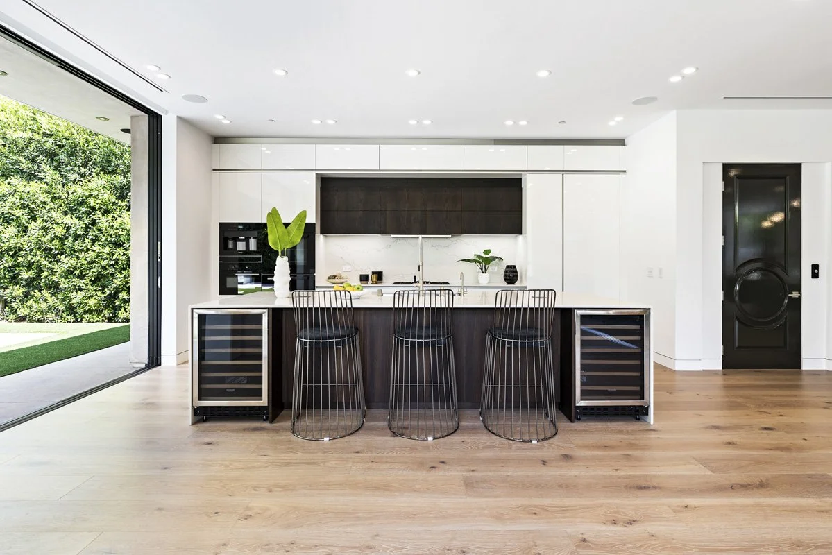 Beverly Hills contemporary kitchen with dark wood cabinetry, white lacquer panels, and built-in wine refrigerators