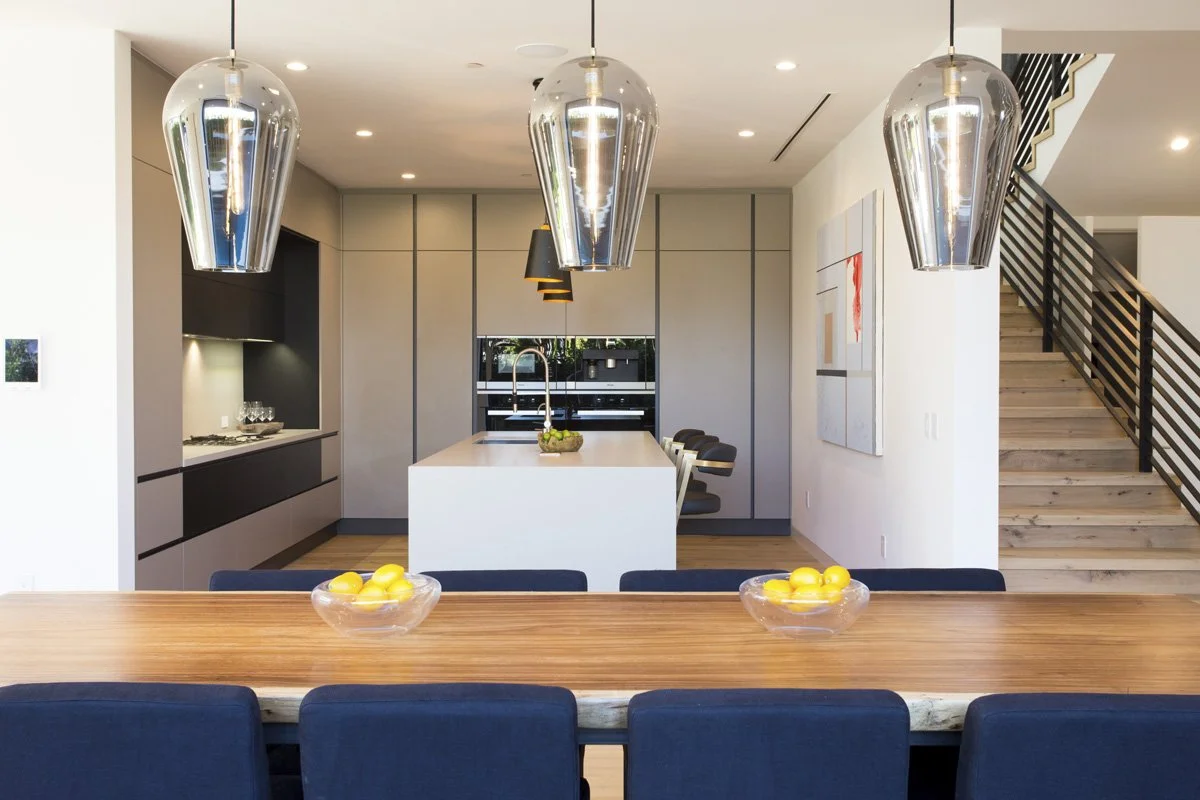 Venice custom kitchen with waterfall island, matte flat-panel cabinetry, integrated wall ovens, and concealed appliance design