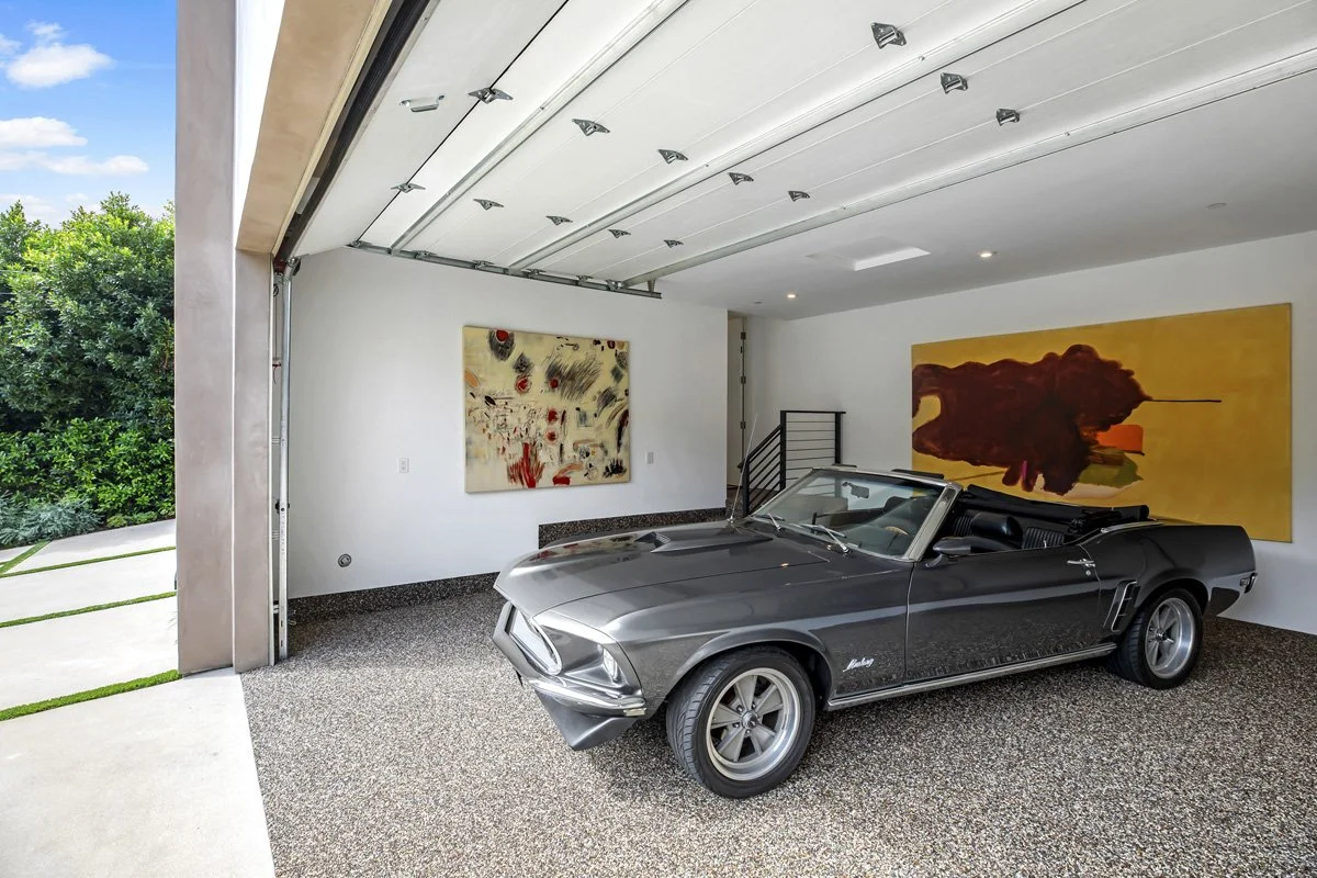 Custom Beverly Hills home garage with finished interior, epoxy flooring, and modern open-door design.