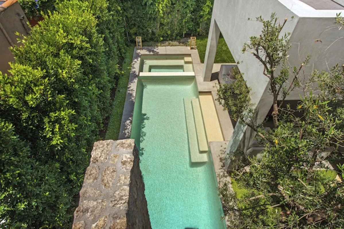Aerial view of backyard pool and spa beside modern courtyard architecture in West Hollywood custom home.